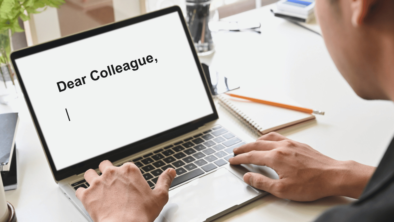 Dear Colleague typed onto a laptop screen by a man