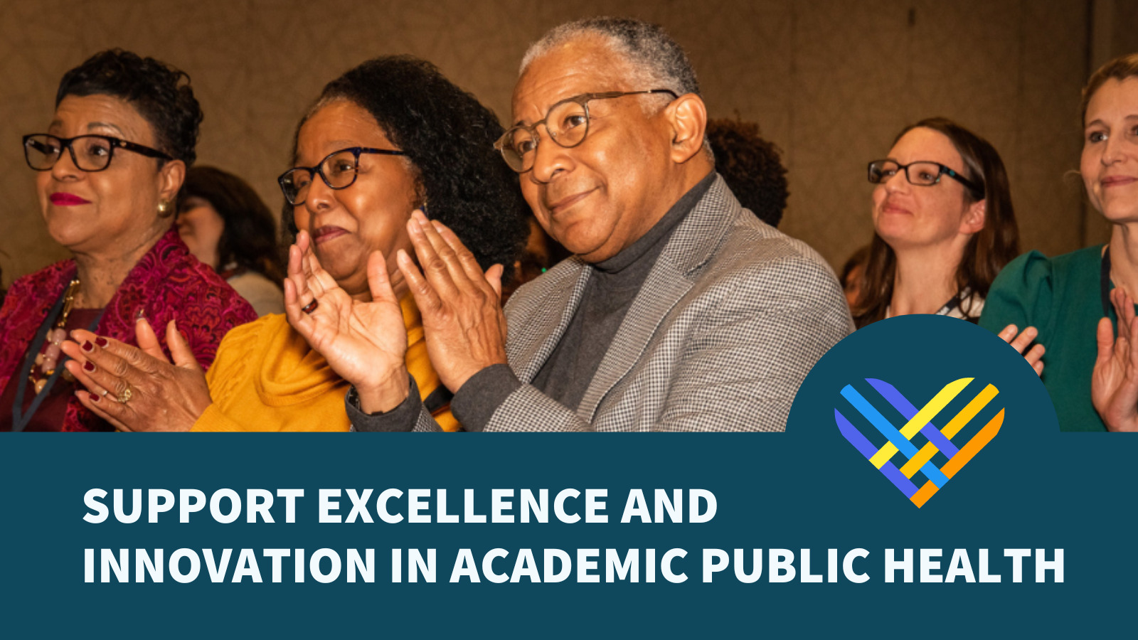 A man clapping his hands surrounded by others at a conference presentation