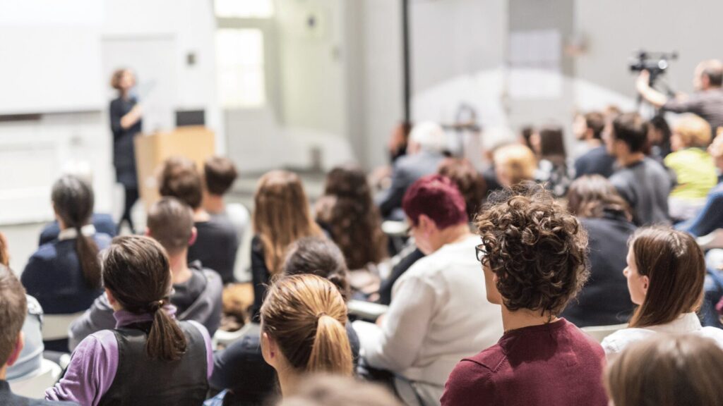 Students facing a lecturer at a podium