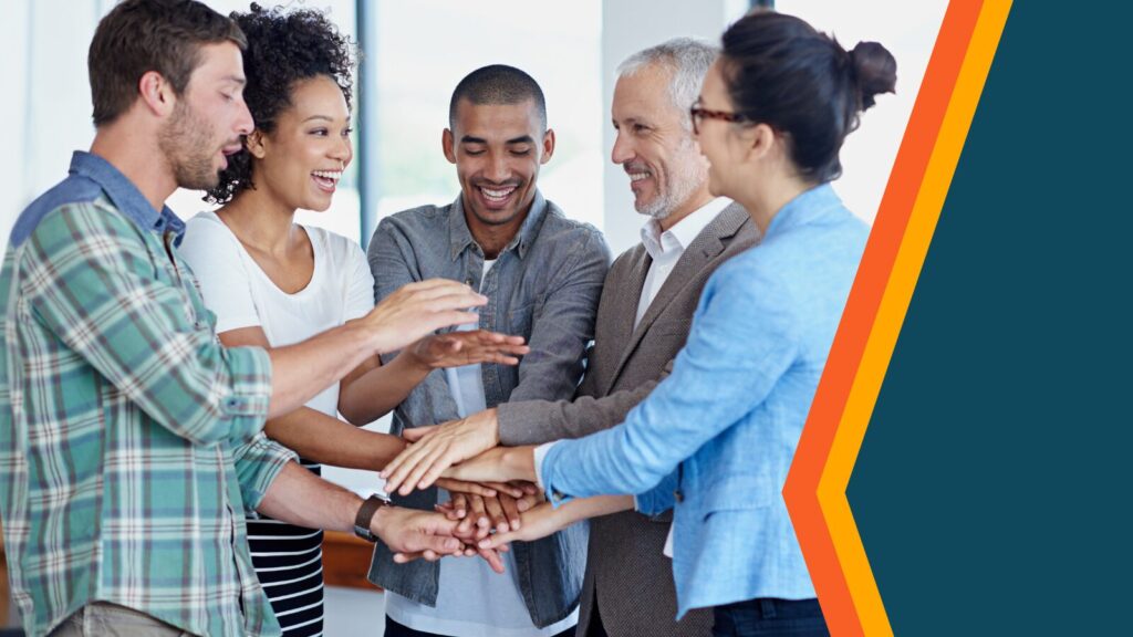 A group of coworkers standing in a circle with hands in center