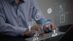 A man using a laptop with graphical images displayed above it