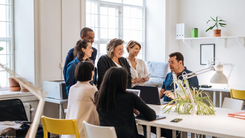 stock image of coworkers gathered around a desk