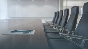 Empty conference room with black chairs and a wooden table featuring a notebook and pen symbolizing preparation and planning