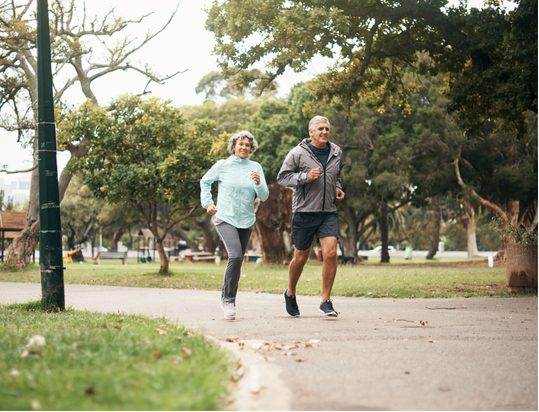 An older couple on a run in a park