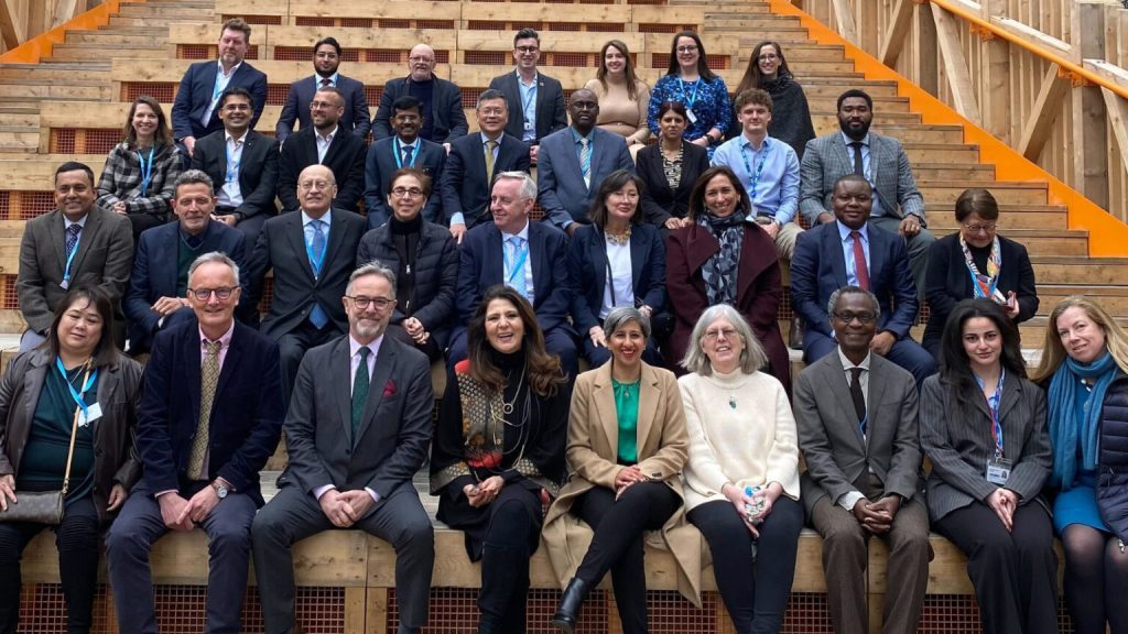 A group of diverse people seated and posed for a group photo