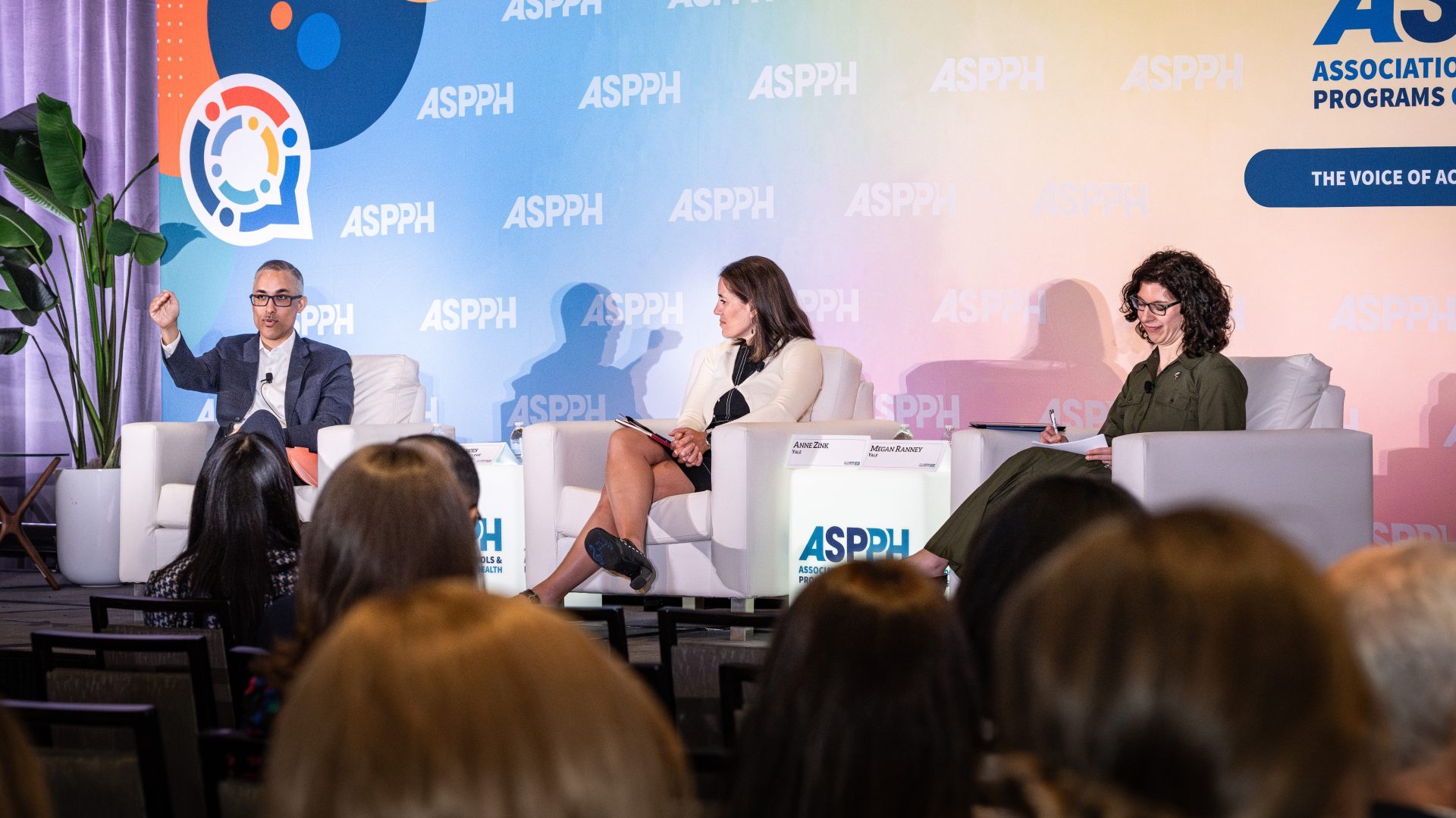 Three speakers sitting on stage