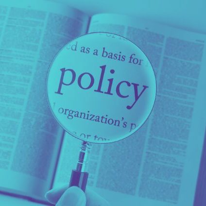The word 'policy' enlarged by a magnifying glass.