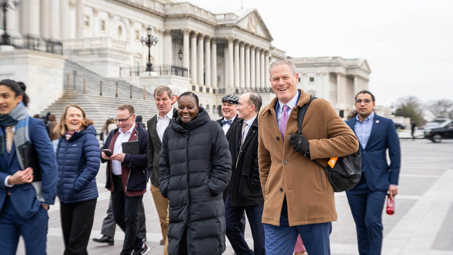 A group of people walking alongside US capitol