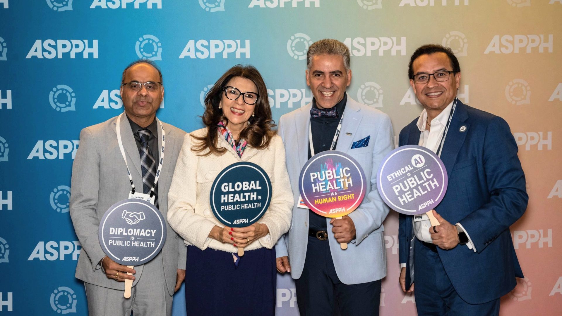 Four people holding prop signs at a photobooth