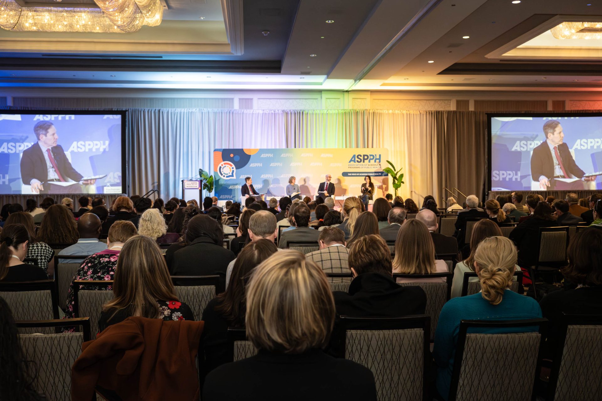 A large audience looking up at a stage with a panel
