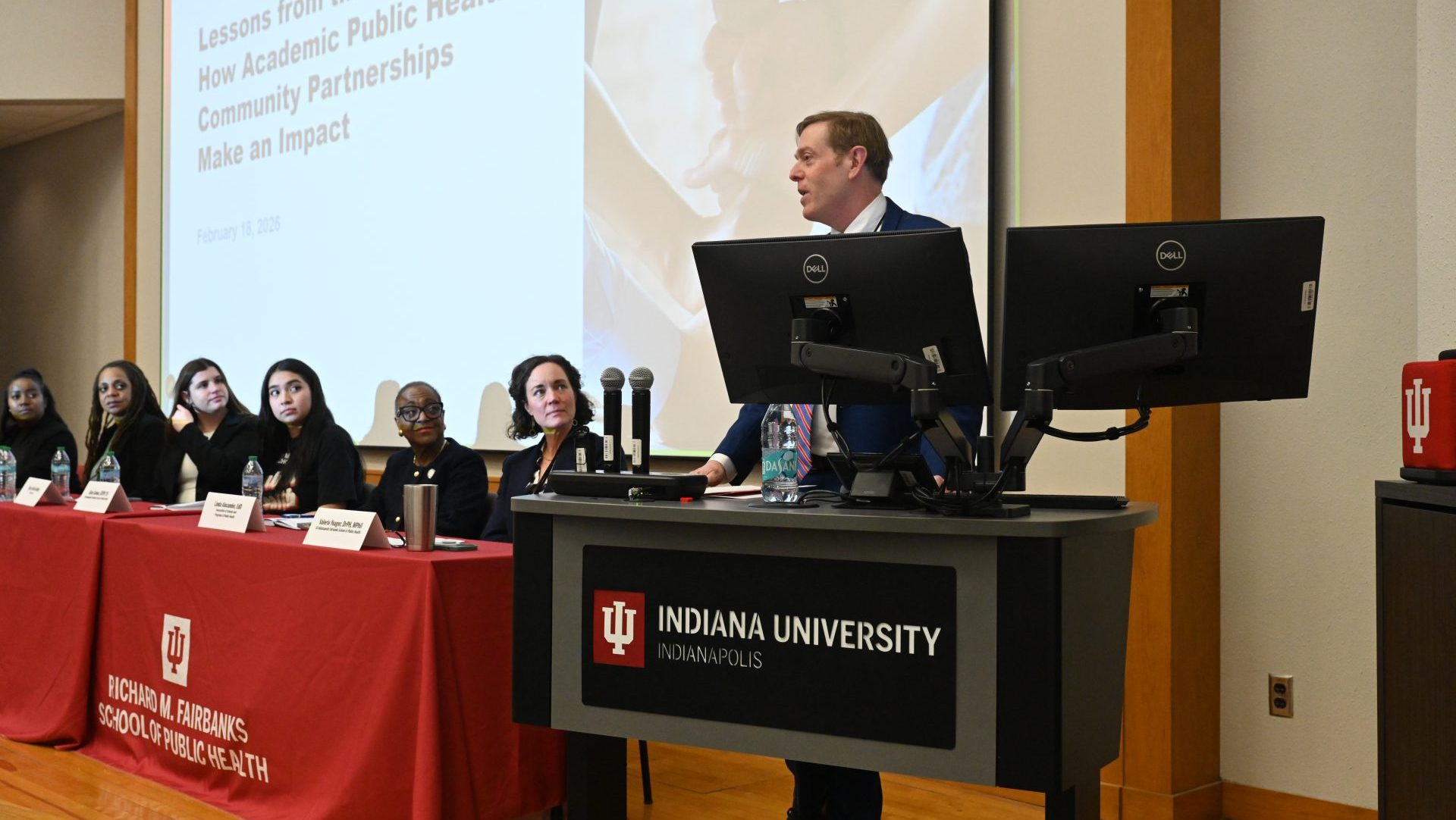 A panel and speaker in front of a podium