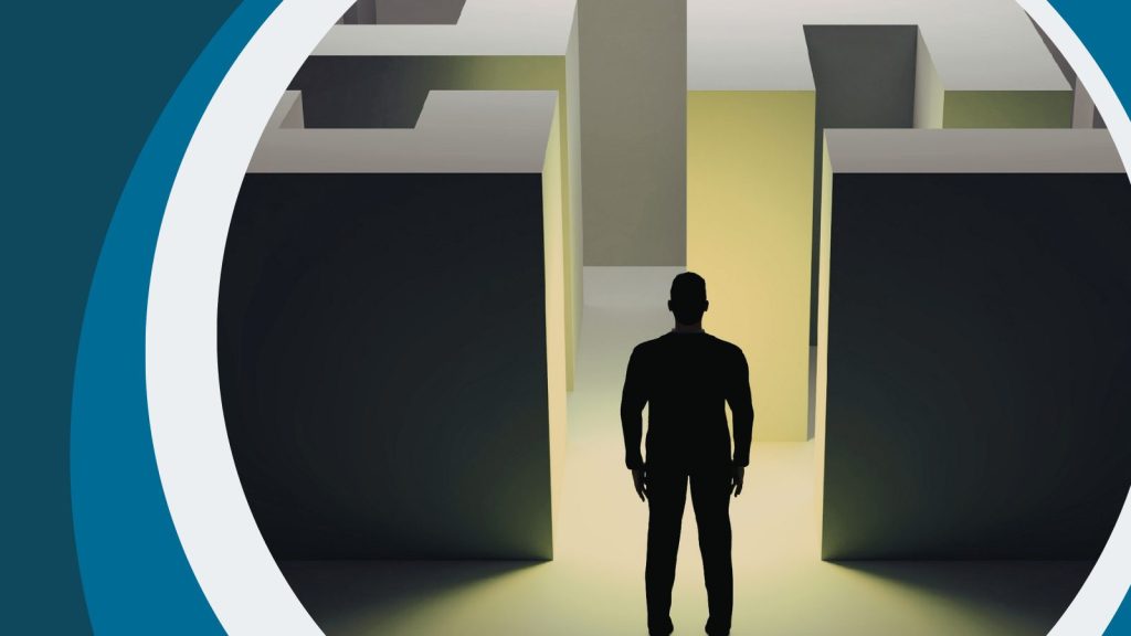 Silhouette of man standing in front of a maze