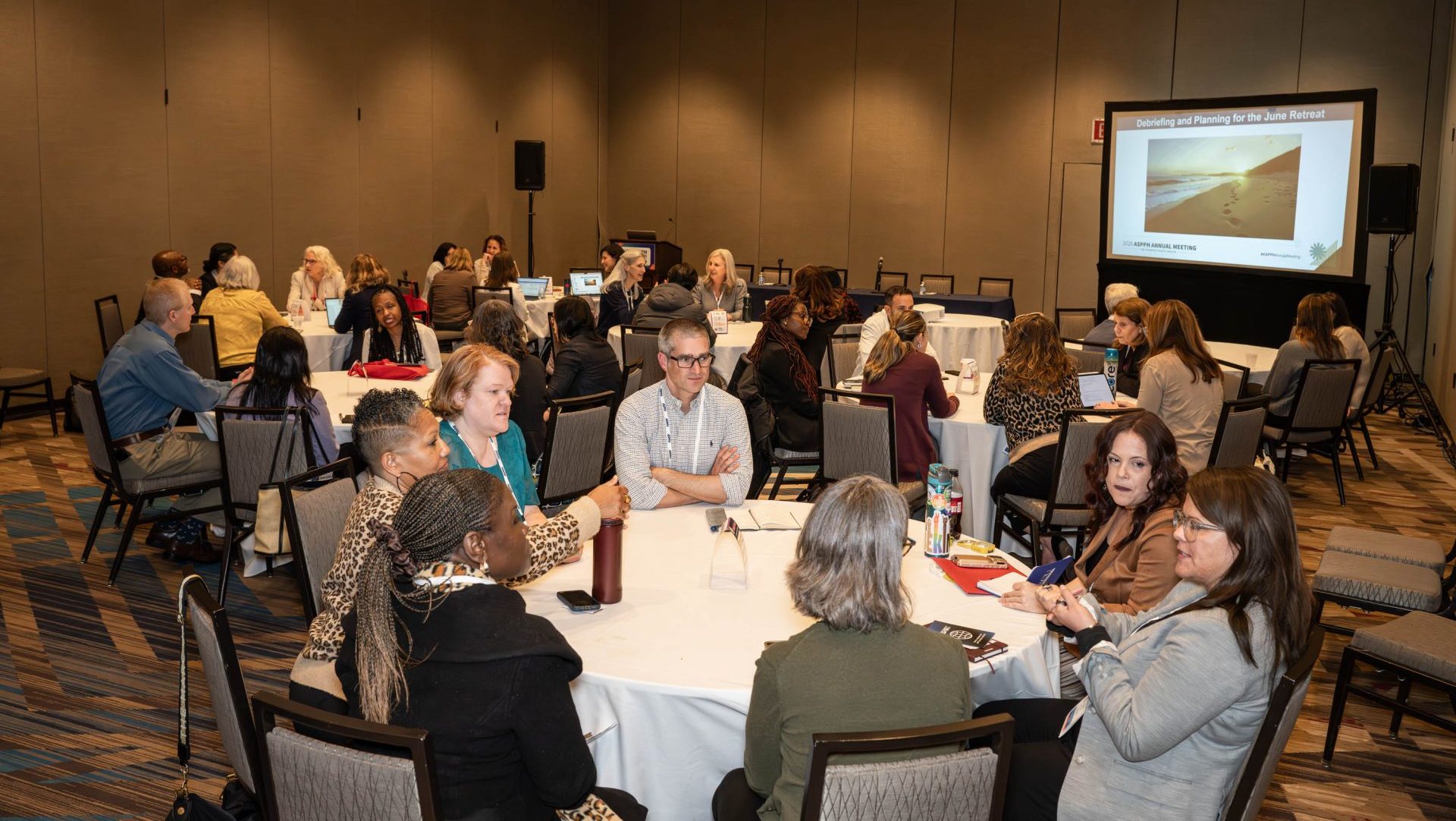 http://Four%20tables%20of%20people%20have%20discussions