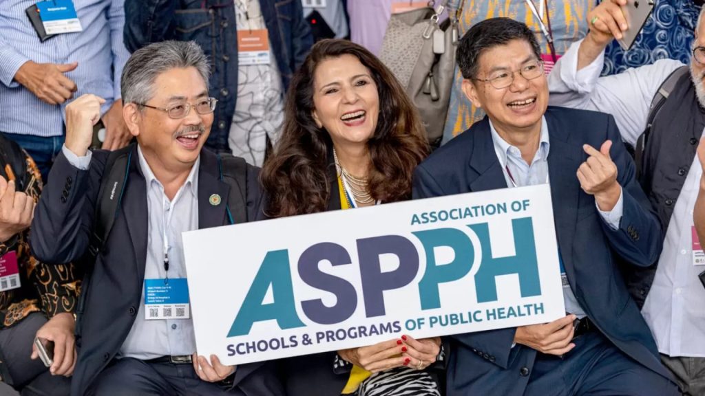 People posing in front of camera holding a sign that reads ASPPH