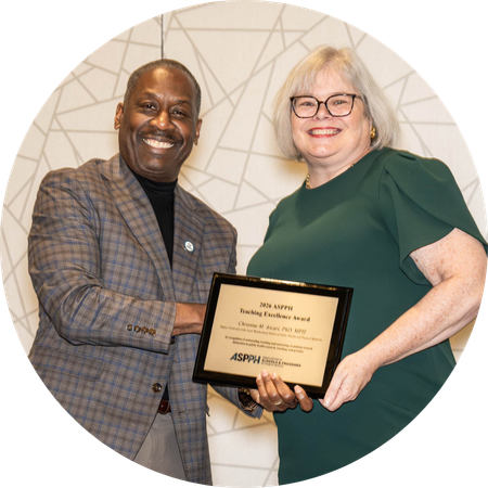 A man and woman shake hands and hold an award