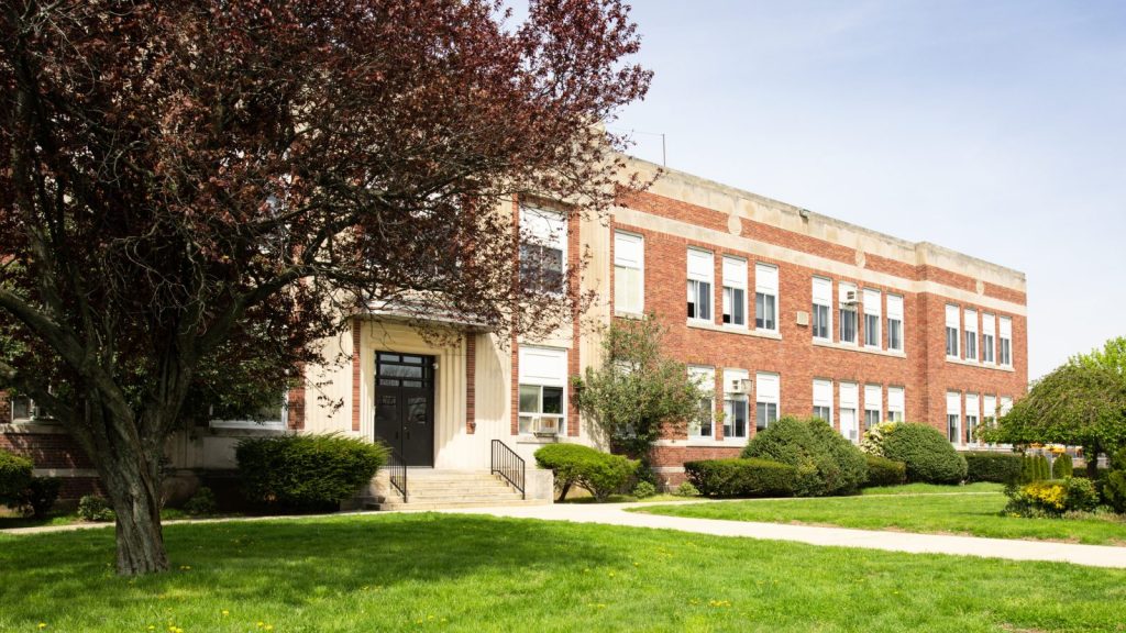 School building with tree in front